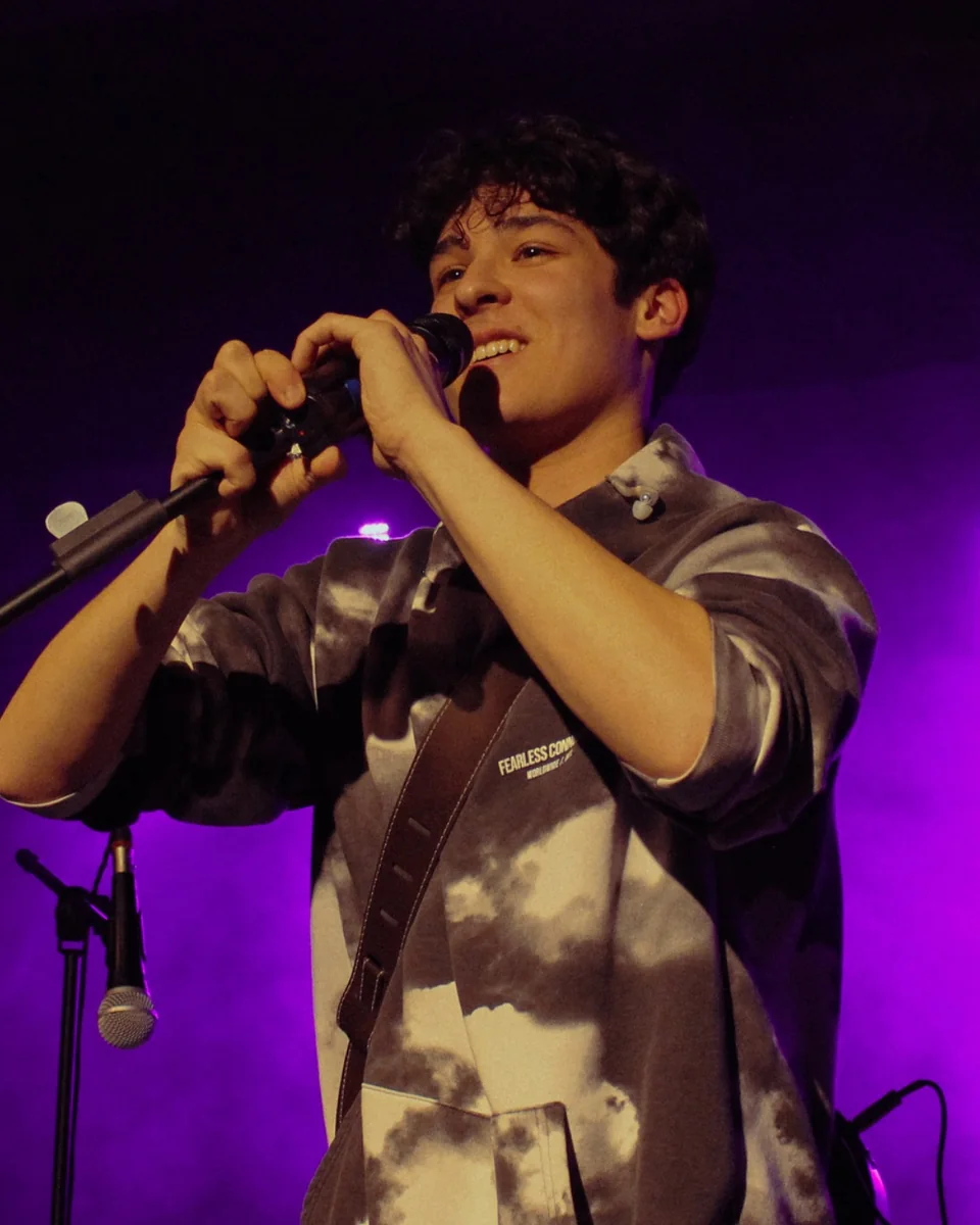 Sam Keanu smiling while performing live on stage